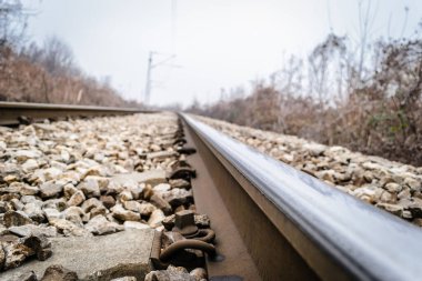 Scenic view of straight railway or railroad track receding into distance on foggy day. The concept of traveling by train.