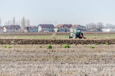 Tarlaları ve traktörü olan kışın panoramik manzarası.