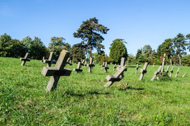 Eski askeri mezarlık. Askeri mezarlığın eski özdeş, ihmal edilmiş beton mezar taşı haçlarının panoramik bir görüntüsü..