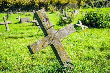 Eski askeri mezarlık. Askeri mezarlığın eski özdeş, ihmal edilmiş beton mezar taşı haçlarının panoramik bir görüntüsü..