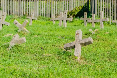 Eski askeri mezarlık. Askeri mezarlığın eski özdeş, ihmal edilmiş beton mezar taşı haçlarının panoramik bir görüntüsü..