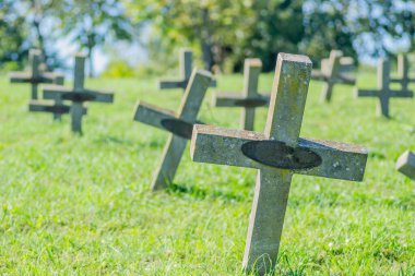 Eski askeri mezarlık. Askeri mezarlığın eski özdeş, ihmal edilmiş beton mezar taşı haçlarının panoramik bir görüntüsü..