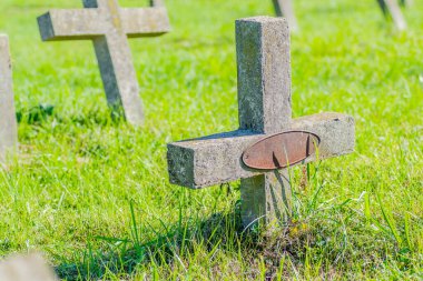 Eski askeri mezarlık. Askeri mezarlığın eski özdeş, ihmal edilmiş beton mezar taşı haçlarının panoramik bir görüntüsü..