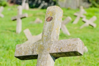 Eski askeri mezarlık. Askeri mezarlığın eski özdeş, ihmal edilmiş beton mezar taşı haçlarının panoramik bir görüntüsü..