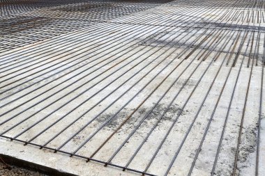 A closeup of steel reinforcement and concrete. Zero level in the construction of a residential building