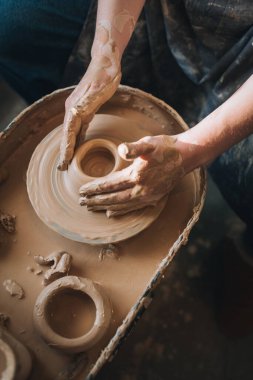 Clay modeling hands on a potter's wheel. Handmade. Ceramic tableware.