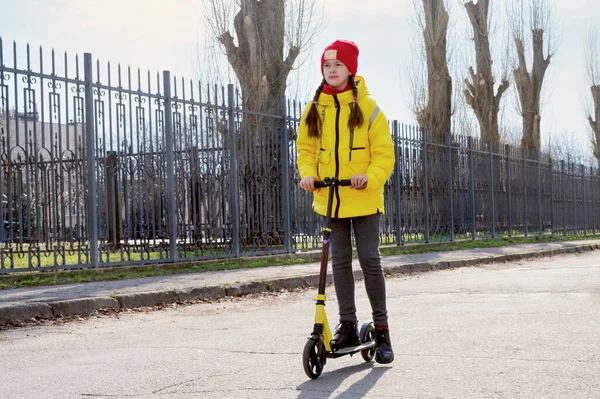 Uma Rapariga Casaco Amarelo Andar Scooter Numa Rua Vazia Conceito — Fotografia de Stock