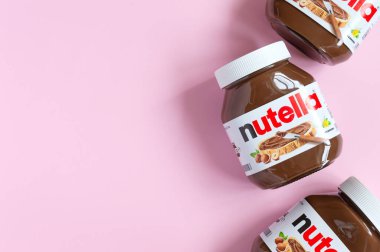 KREMENCHUG, UKRAINE - 9 Ekim 2021: Nutella fındık çikolatası pembe bir kavanozda serpilmiş. Kopyalama alanı olan yaratıcı yiyecek arkaplanı.