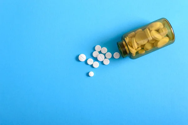 Pastillas Redondas Blancas Esparcidas Una Botella Marrón Sobre Fondo Azul — Foto de Stock