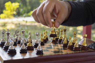 Açık hava satranç konsepti, boş zaman. Adam kız gibi hareket ediyor. Seçici odak, yakın plan.