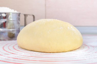 Mutfak masasında hamuru yuvarlamak için özel silikon fırın hamuru üzerinde ham maya hamuru. Pizza, pasta, fırın ve diğer fırın ürünleri için hamur hazırlığı. Ev yapımı konsepti..