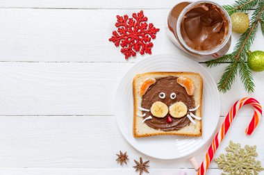 2022 yılının yenilebilir sembolü olan kaplan şeklinde çikolatalı sandviç. Noel kahvaltısı teması, fotokopi alanı. Çocuklar için taze meyve ve kakaolu tost. Üst görünüm