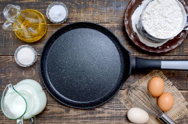 Krepleri pişirmek ve ahşap zemin üzerine malzemeler koymak için taş kaplamalı boş tava siyahı. Kahvaltı, üst manzara..