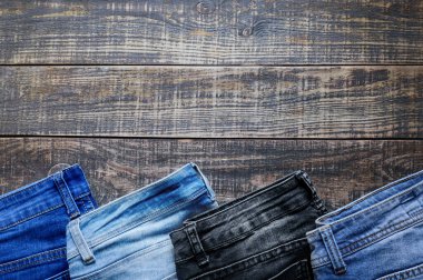 Kırsal ahşap arka planda kot pantolon ve fotokopi alanı. Rahat pantolonların çeşitliliği, üst manzara.. 