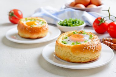 Beyaz arka planda yumurta ve pastırma dolu fırında çörekler..