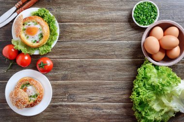 Fotokopi alanı ile yemek yapmak için gerekli malzemeler. Yumurtayla doldurulmuş çörek, taze otlar, ahşap arka planda çiftlik yumurtaları. Kahvaltı konsepti, yumurta tarifleri..