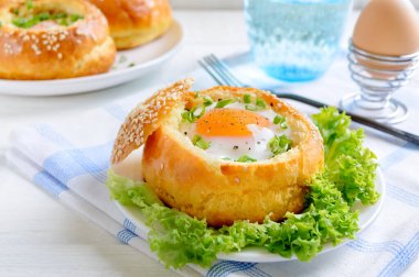 Susamlı ekmeğin içinde pişmiş yumurta sarısı ve taze otlarla servis edilmiş. Kıta kahvaltısı.