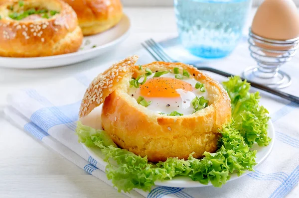 Susamlı ekmeğin içinde pişmiş yumurta sarısı ve taze otlarla servis edilmiş. Kıta kahvaltısı.