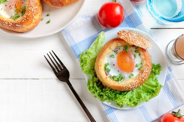 鸡蛋在松软的面包里烤着 上面夹着火腿和新鲜的香草 美味而快捷的早餐 顶部视图 — 图库照片