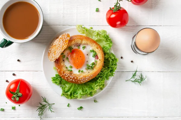Lezzetli kahvaltı, yumurtalı çörek ve taze otlar. Üst Manzara. Yumurtanın tarifleri.