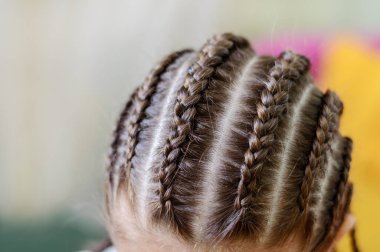 Şenlikli, modern saç stili ve bir sürü küçük örgülü örgü. Örgü dokuları. Yakın çekim, seçici odaklanma