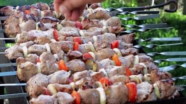 The cook salts the meat during frying. Grilling shashlik, close-up.