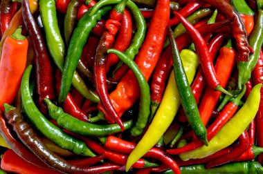 Colorful green, red and yellow chili peppers, natural background. Fresh capsicum for sale at market.