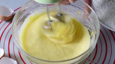 Hareketli karıştırıcı cam bir kasede yumurta çırpıyor omlet ya da dought yapmak için, yakın plan.