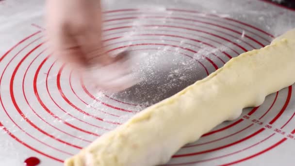 女性の手は小麦粉で表面を振りかけ 焼く前にテーブルの上に詰め物で酵母の生地のロールを形成します クローズアップ — ストック動画