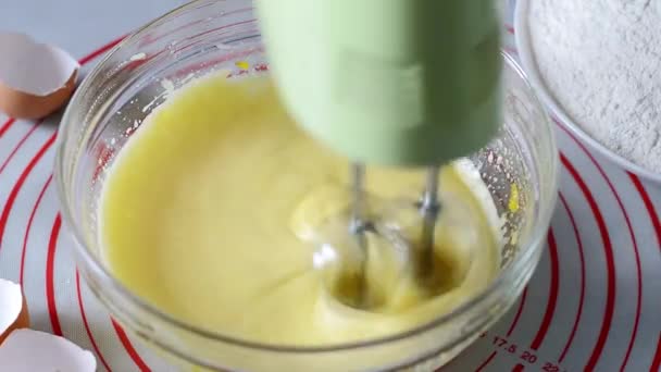 電気ミキサー精力的にガラスボウル クローズアップで鶏の卵を泡立て器 自家製ベーキングのステップバイステップのレシピ — ストック動画