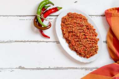 Beyaz ahşap arka planda tabakta acı biber. Gürcistan mutfağı.