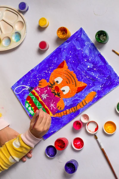 Un enfant peint un chat et un sapin de Noël avec des peintures. Les enfants noël dessin de près. — Photo