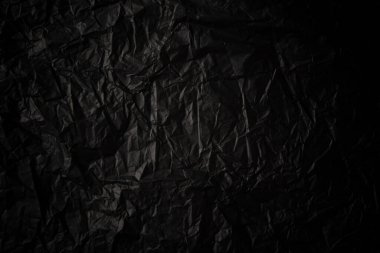 Buruşturulmuş siyah kağıt dokusu.