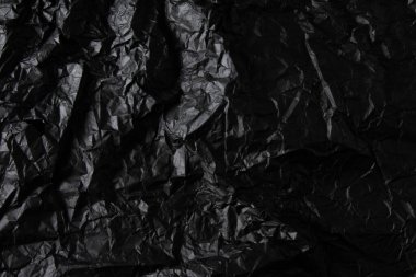 Buruşturulmuş siyah kağıt dokusu.