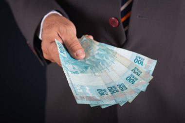 İş adamı sana Brezilya parası gösteriyor. iş kavramı.