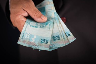 İş adamı sana Brezilya parası gösteriyor. iş kavramı.