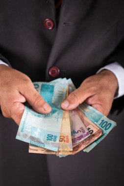 İş adamı sana Brezilya parası gösteriyor. iş kavramı.