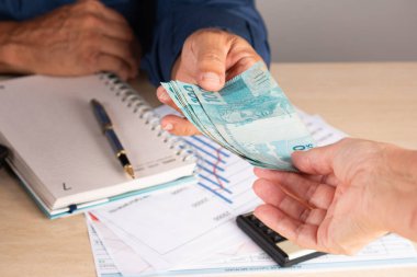 İş adamı anlaşma yaparken ortağına para veriyor. iş ve finans kavramı.