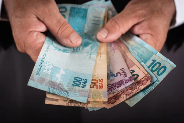 İş adamı sana Brezilya parası gösteriyor. iş kavramı.