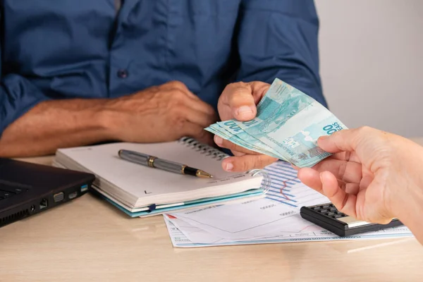 İş adamı anlaşma yaparken ortağına para veriyor. iş ve finans kavramı.