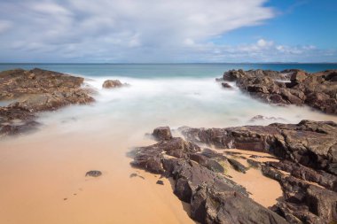 landscape with long exposure of sea and rocks on the coast of Bahia Brazil.