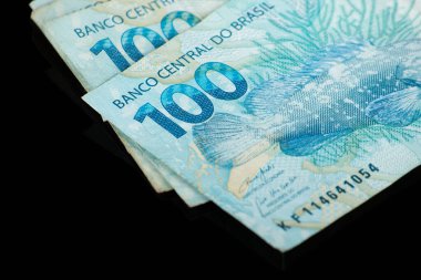 Brezilya parası işte. Siyah arka planı olan 100 reais banknot. finans kavramı.