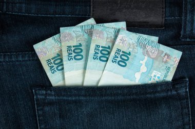 Finans konsepti. Brezilya 100 reais banknotları kot pantolon cebinde.