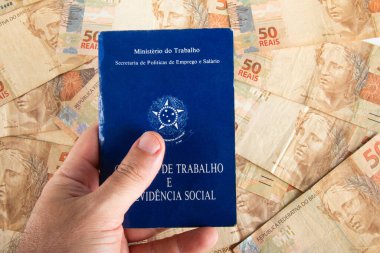 Elde tutulan Brezilya evrak işleri ve sosyal güvenlik (Carteira de Trabalho e Previdencia Social) 50 reais banknotla. Brezilya parası..
