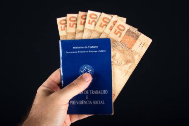 Elde tutulan Brezilya evrak işleri ve sosyal güvenlik (Carteira de Trabalho e Previdencia Social) 50 reais banknotla. Brezilya parası..