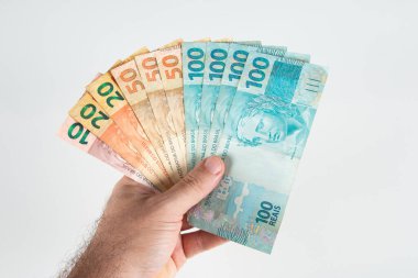 Brezilya para banknotlarıyla el ele tutuşmak. Brezilya finans kavramı.