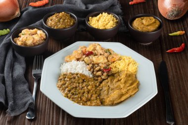 Caruru. Vatapa, fasulye, pirinç, karides ve farofa eşliğinde bamya ve kurutulmuş karidesten geleneksel Afro-Brezilya yemeği.