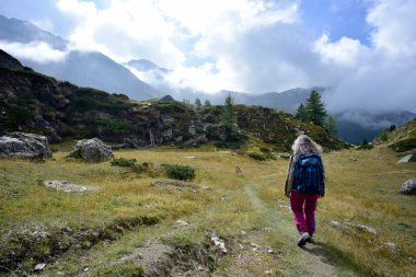Valle d 'Aosta' da Becca d 'Aran' dan vadiye doğru alçak bulutlu bir yolda yürü.