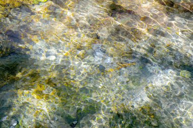 Bir doku oluşturan bir derenin suyundaki yansımalar.