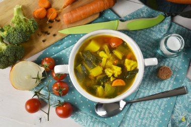 Beyaz bir seramik kasede büyülenmiş sebze çorbası, içinde bazı malzemeler var.